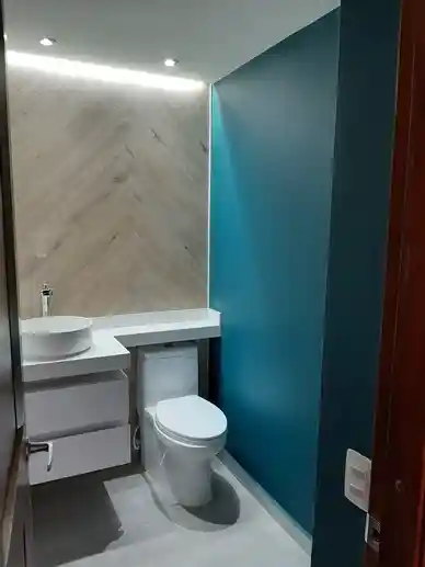Baño social con muro iluminado